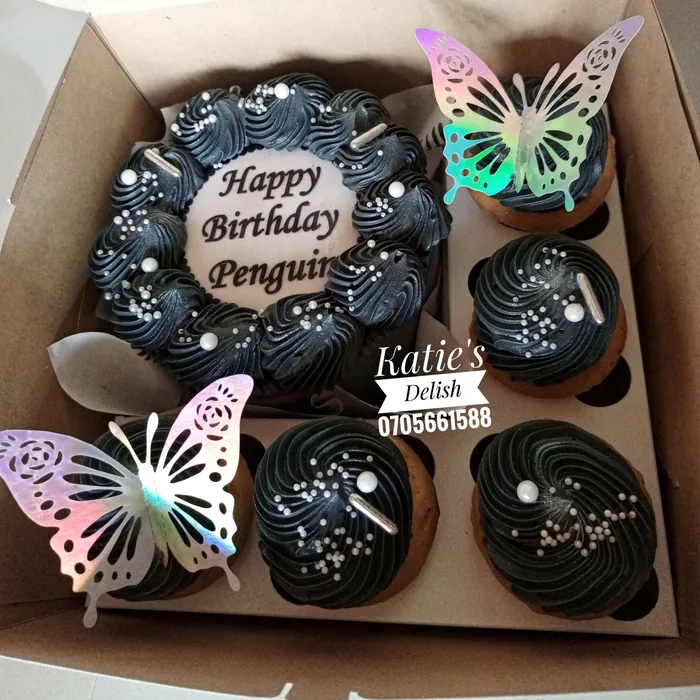 Black birthday cake with matching cupcakes